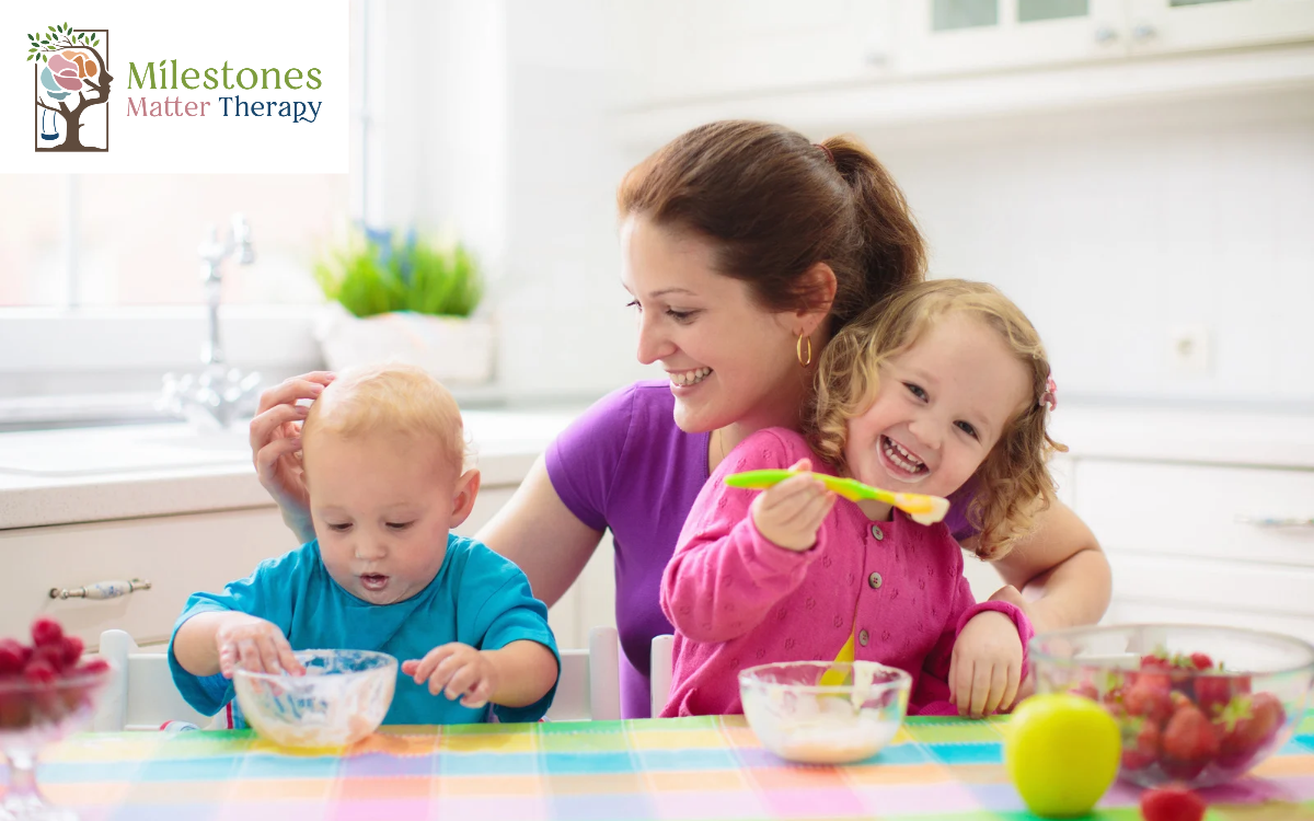 mom feeding two children at dinner table