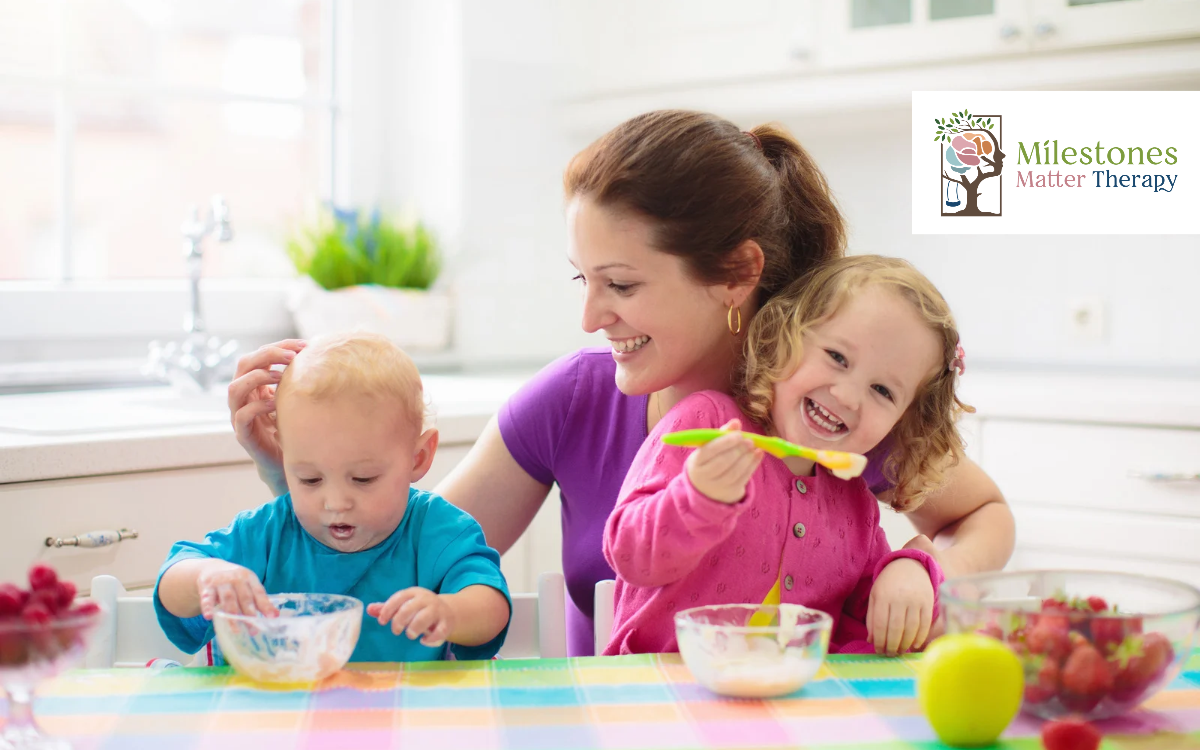 mom feeding two children at dinner table