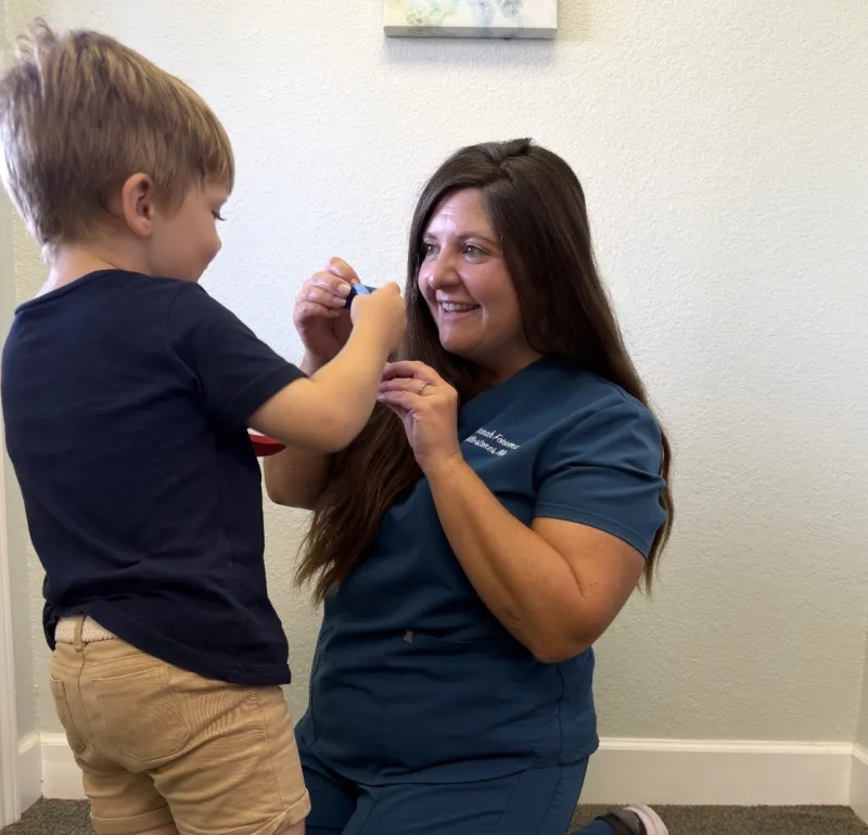 Therapist kneeling down to interact with a toddler during an early intervention session